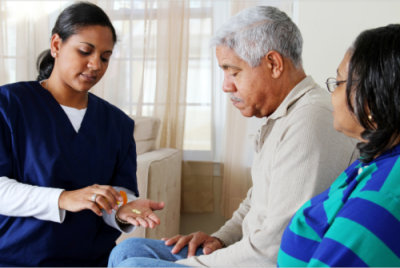 caregiver giving senior man a medication